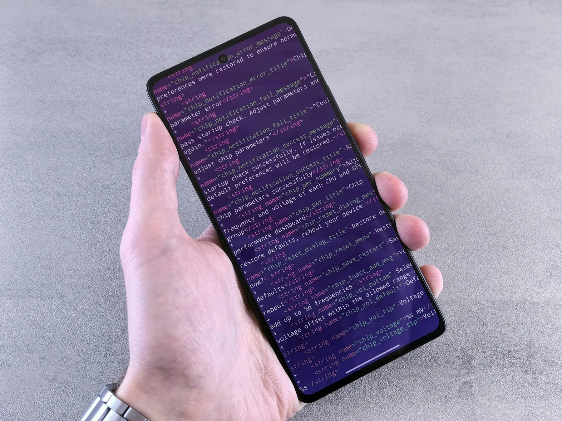A smartphone displaying colorful programming code